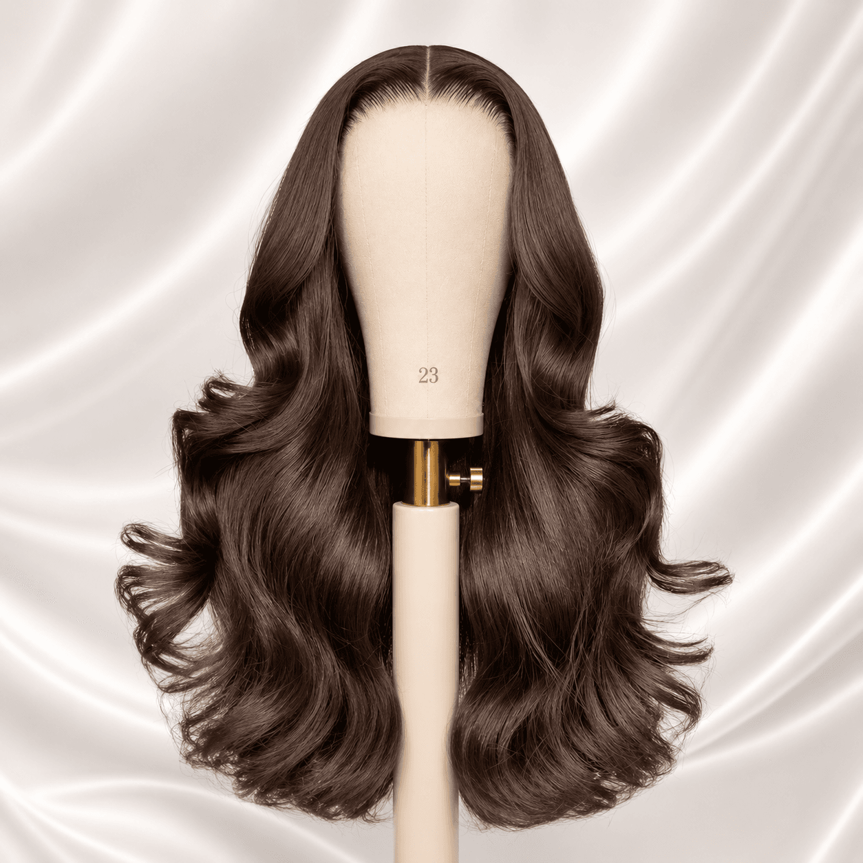 Long glossy brunette wig styled in soft waves on a mannequin head